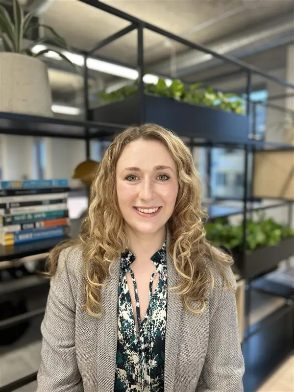 Harriet Hirst, Peaches volunteer, white female, long blonde curly hair, wearing abstract shirt and grey jacket
