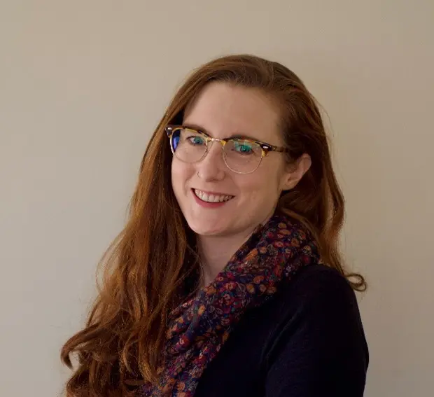 Grace, Peaches Policy and Advocacy volunteer, white female, long auburn hair, wearing blue top floral scarf and glasses