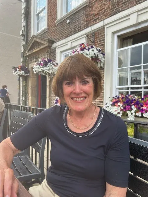 Sharon, Peaches finance trustee, white female, short brown, wearing blue top