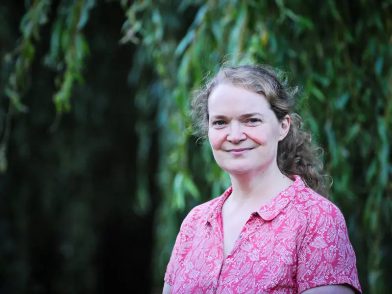 Image of Professor Emma Crosbie, white female, long curly hair wearing pink patterned shirt